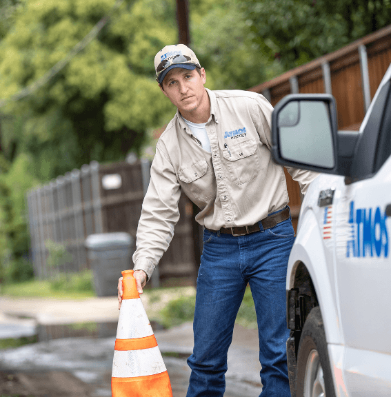 Atmos Energy employee setting out safety cones in alley